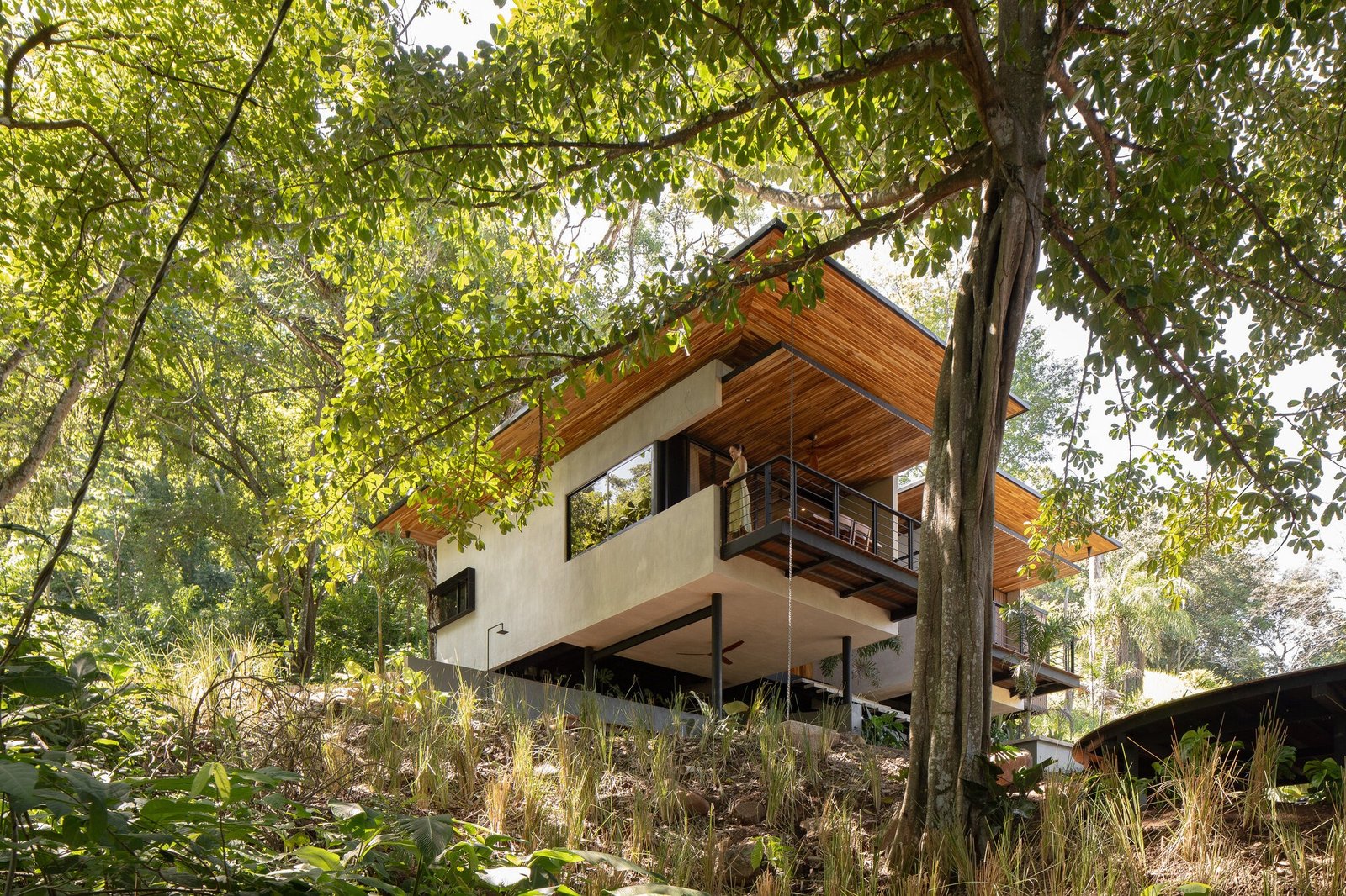 Exterior view of Villas Raíces elevated on stilt columns nestled within dense tropical forest canopy.