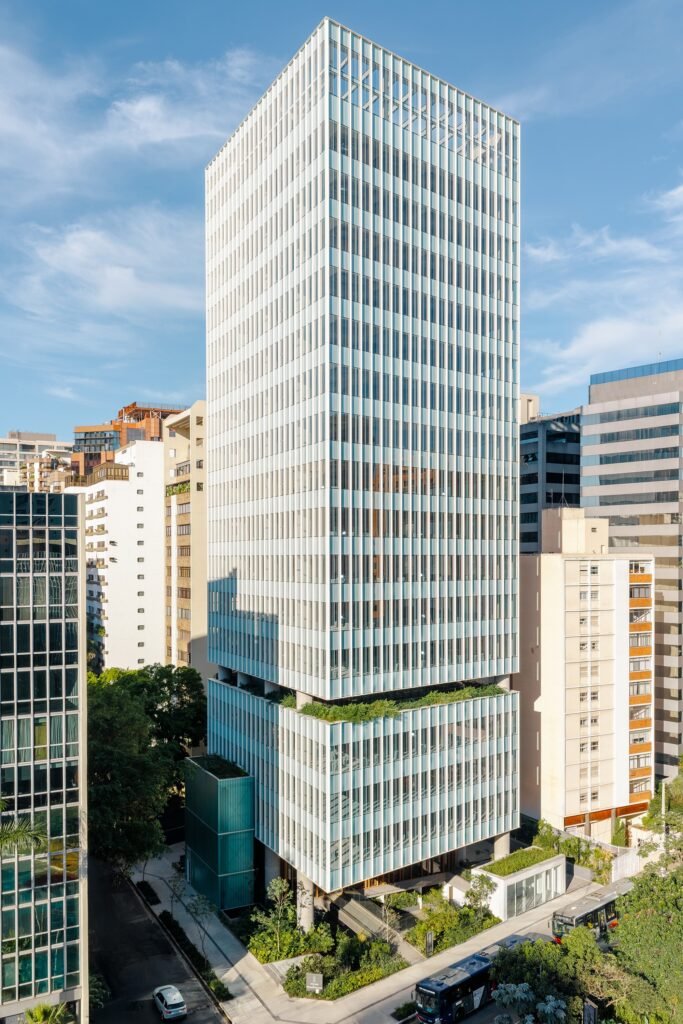 Aerial drone shot of the Jer&ocirc;nimo Faria Lima tower in S&atilde;o Paulo showing its two stacked volumes separated by a sky garden terrace amidst surrounding high-rises.