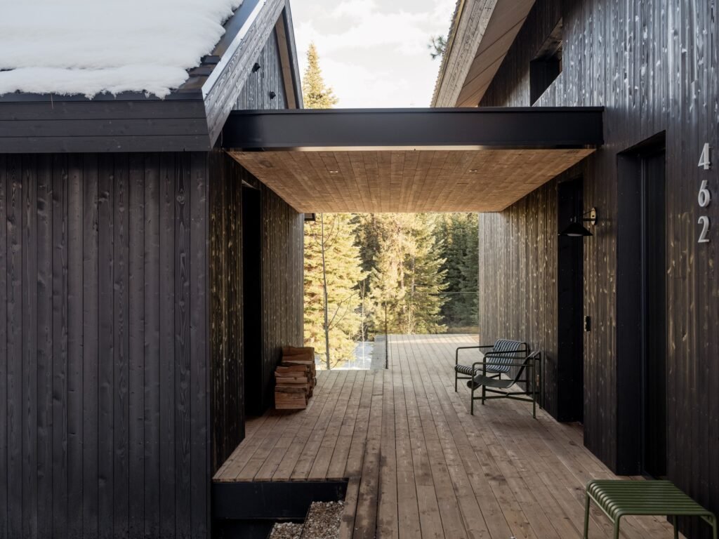 Outdoor wooden walkway and covered breeze-way framed by dark wood cladding and timber ceiling.