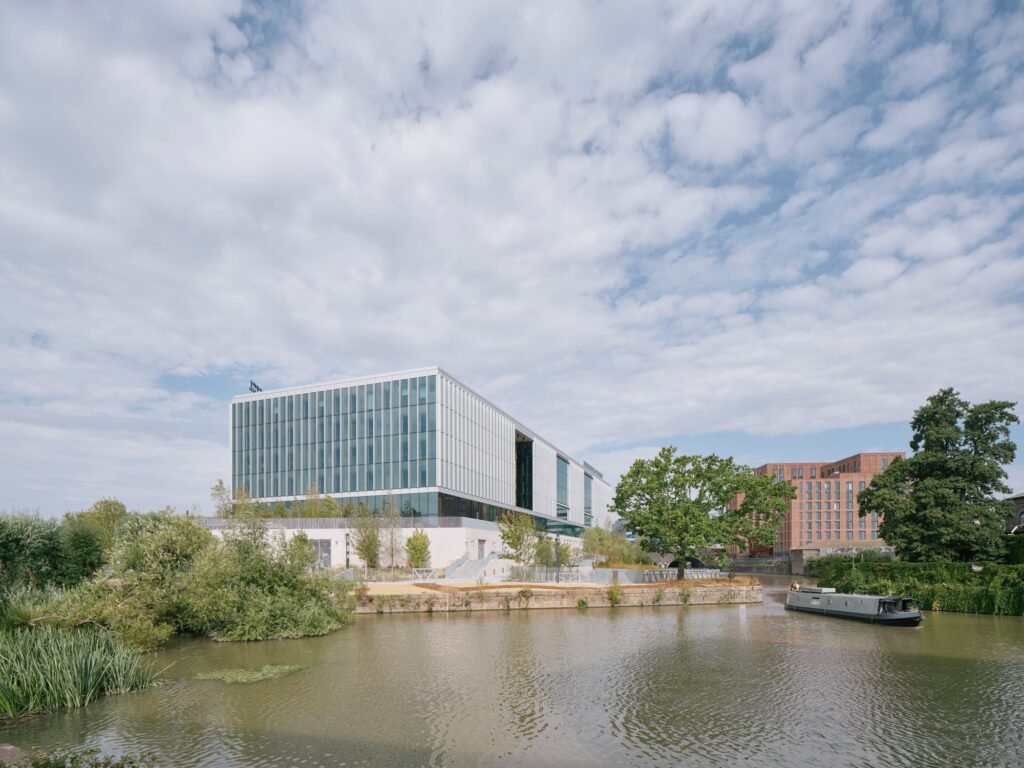 Temple Quarter Enterprise Campus building seen across the Floating Harbour water body in Bristol under a cloudy sky.