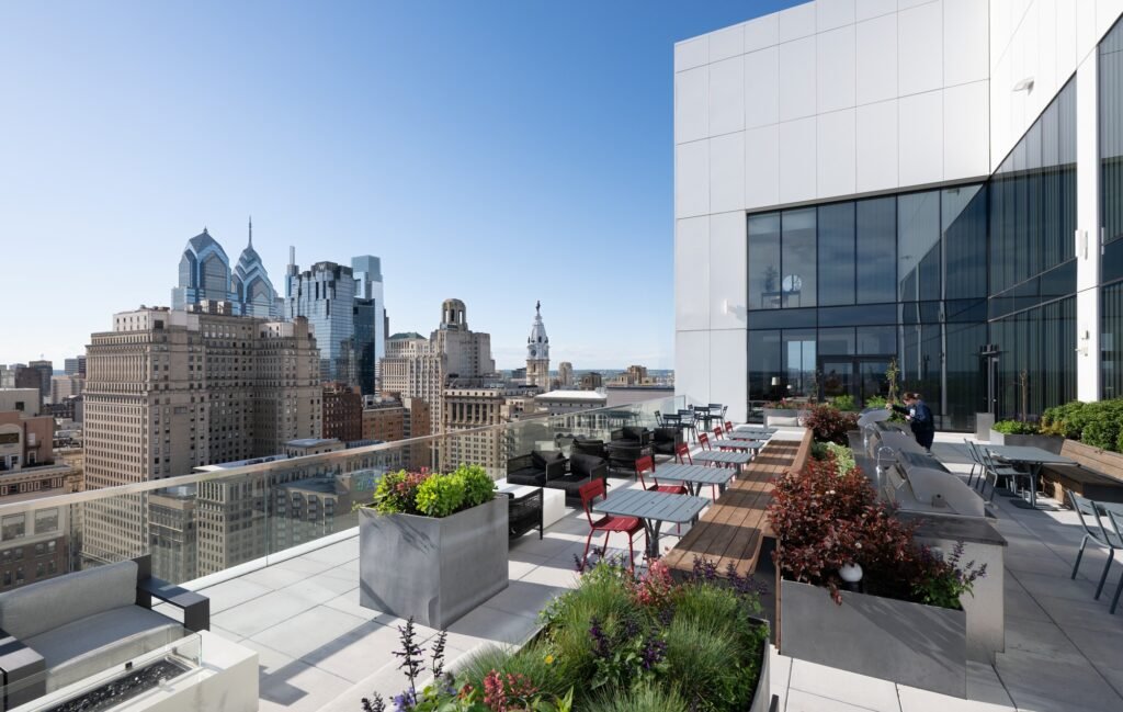 Outdoor rooftop terrace deck at 210 South 12th with seating, planters, and panoramic views of the Philadelphia skyline.