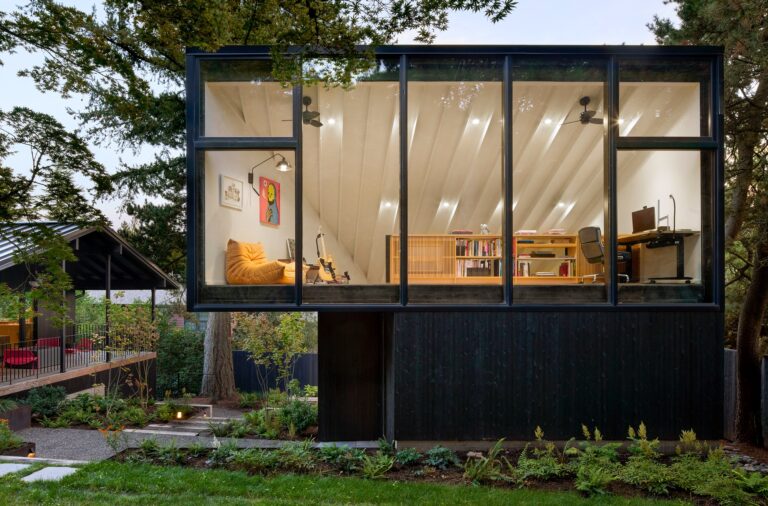 Exterior view of the detached two-story studio structure at 4015 House Studio in Portland featuring a large upper glass window and dark charred wood cladding.