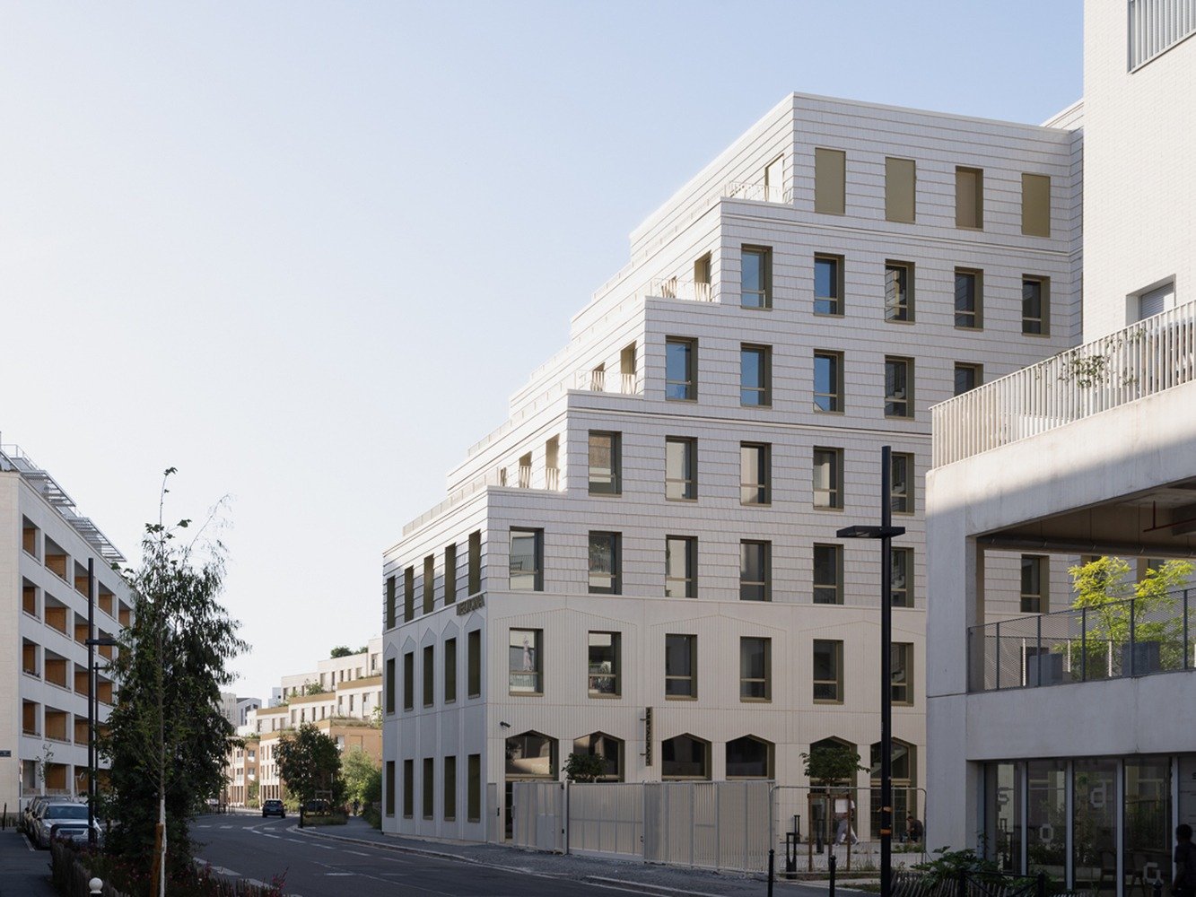 Stepped terracotta facade of Donnan Health Center in Bordeaux showing terraced volume and street view.