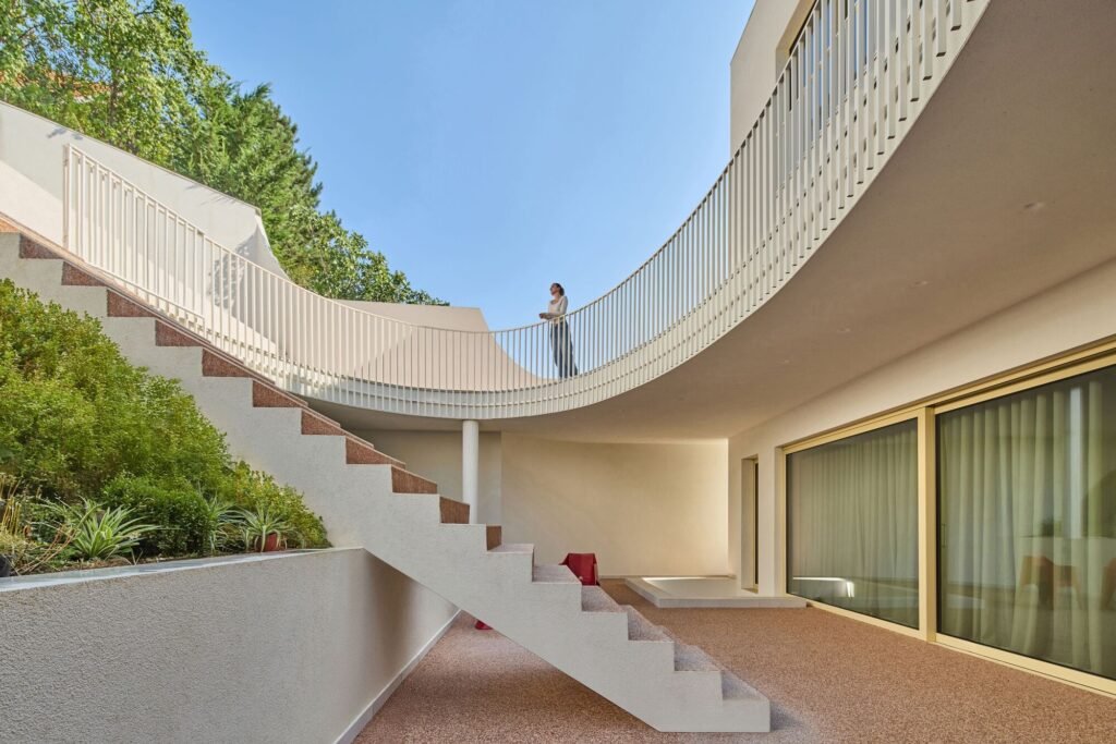 Curved outdoor circulation path and floating stairs in the courtyard of The Gallery residence.