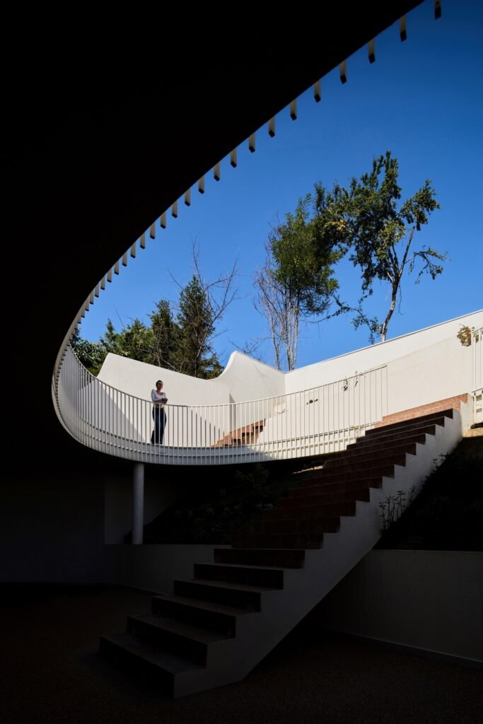 Low-angle view of the infinite staircase and elliptical courtyard opening pointing toward the sky in The Gallery.