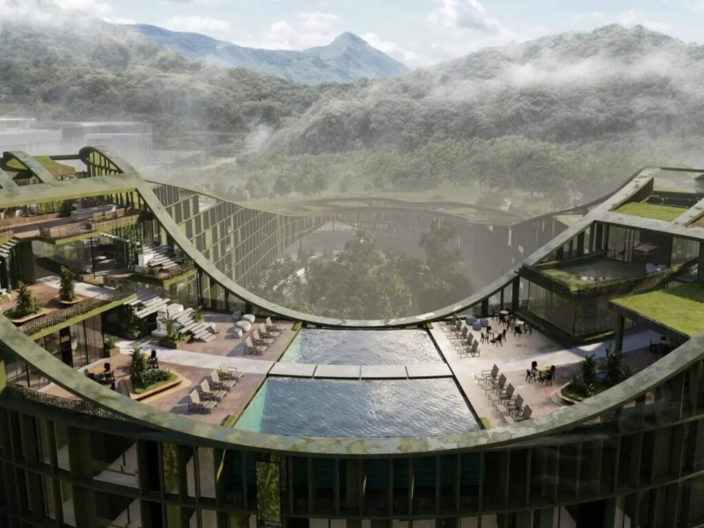 Rooftop terrace with infinity swimming pool overlooking misty mountains and lush green landscape.