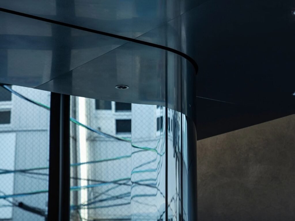 Architectural architectural detail showing curved metallic surface and reflective column inside 2050 Coffee.