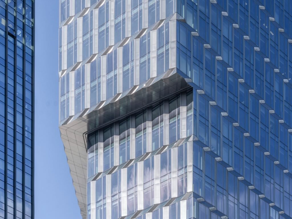 Close-up of the folded stainless steel panel facade and reflective glass panels of the Kingdee HQ Tower.
