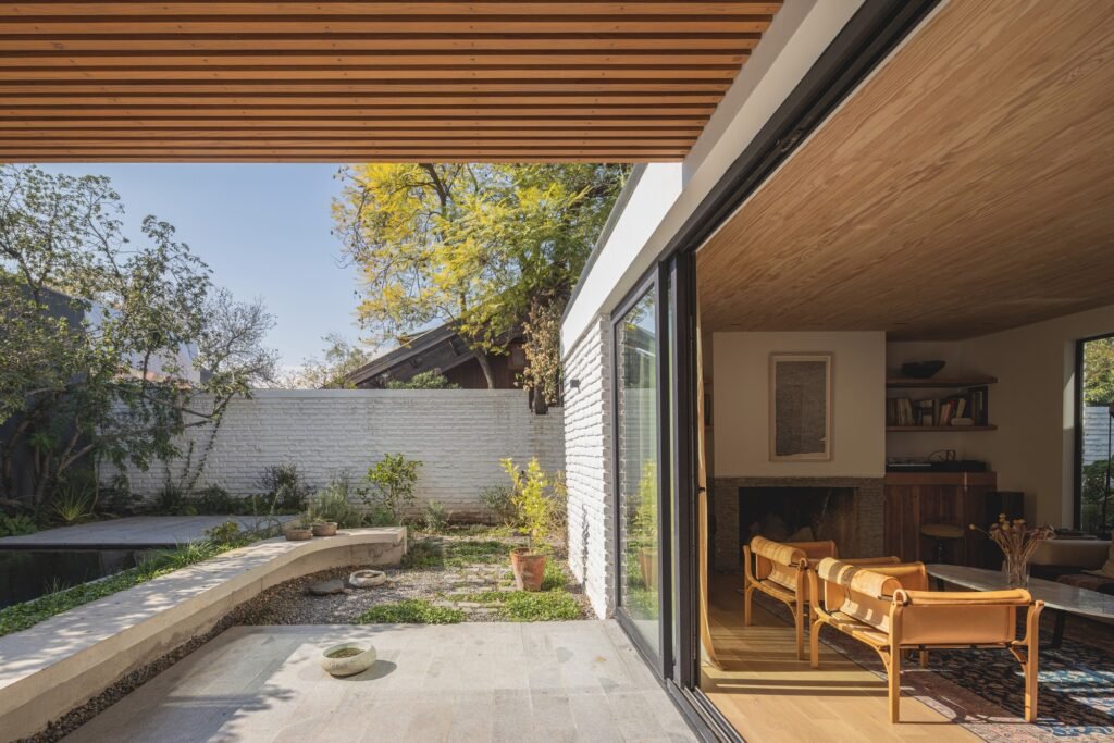 Living room with sliding glass doors opening directly onto a paved outdoor patio and garden space.