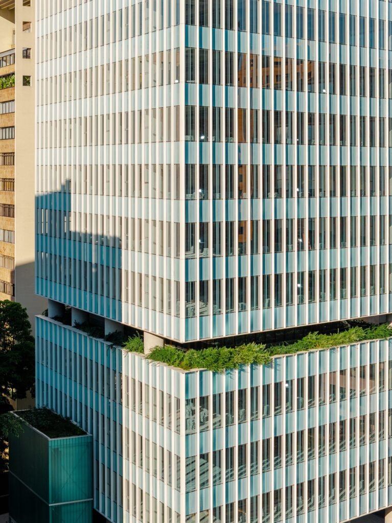 Close-up aerial view of the silk-screen printed glass facade pattern and intermediate landscaped sky garden terrace break.