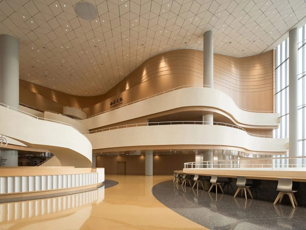 Wide shot of the main interior lobby showing wood-paneled sweeping walls, reading desks, and high ceilings.