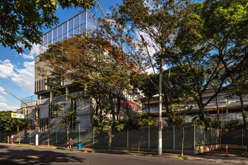Street view of Beacon School campus featuring contemporary High School block, adapted industrial sheds, and surrounding urban greenery.