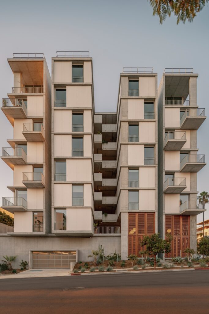 Exterior elevation of KAYA showing its deconstructed four slender volumes, central open-air corridors, and upper balconies.