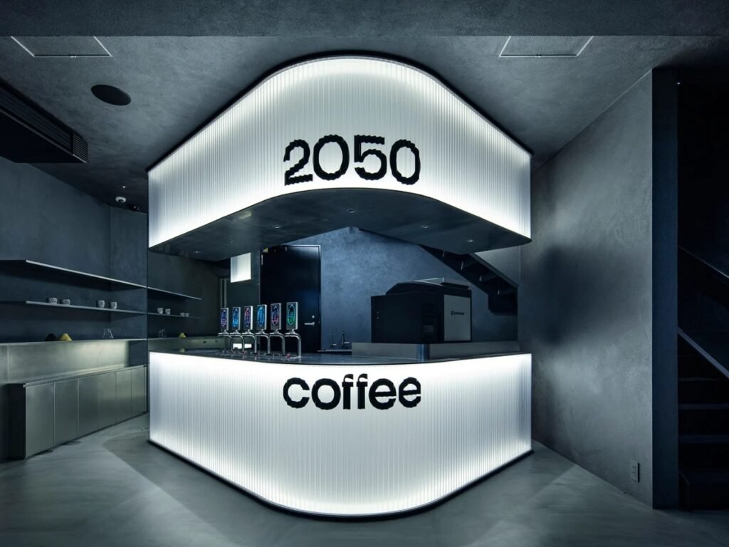 Angled view of glowing coffee counter with draft taps, espresso machine, and rear wall shelves.