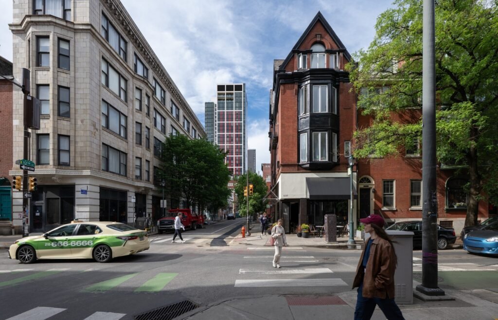 Street intersection at 12th Street featuring pedestrians, a passing taxi, historic buildings, and 210 South 12th in the background.