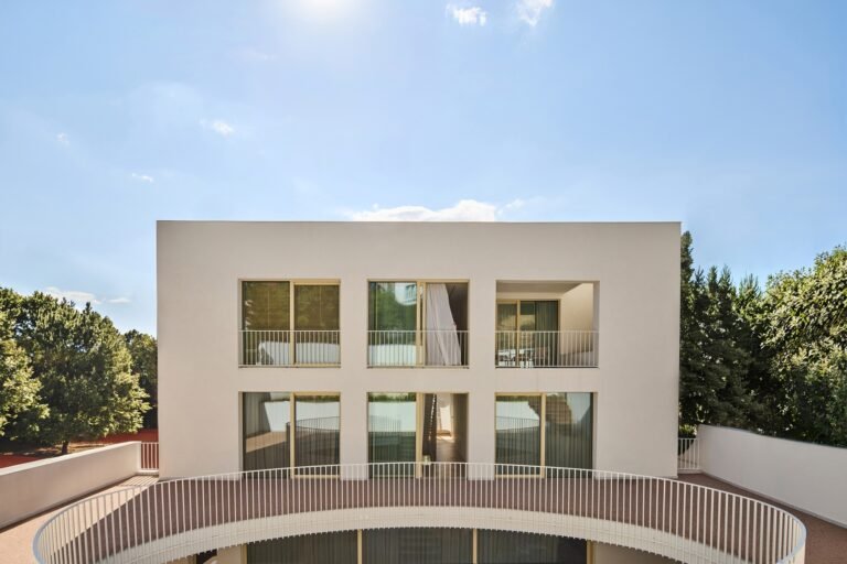 Symmetric internal facade view across the upper balcony overlook toward large glazed openings in The Gallery.