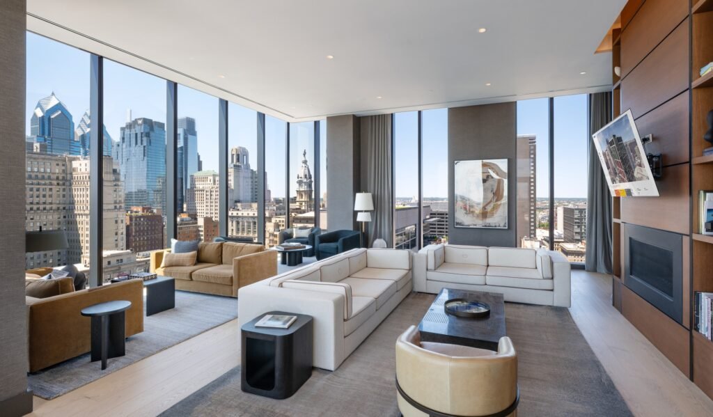 Modern interior resident lounge at 210 South 12th featuring floor-to-ceiling windows overlooking the Philadelphia city skyline.