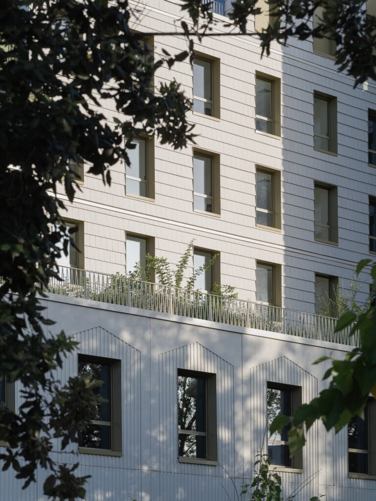 Close-up of terracotta tile facade texture and window openings at Donnan Health Center.