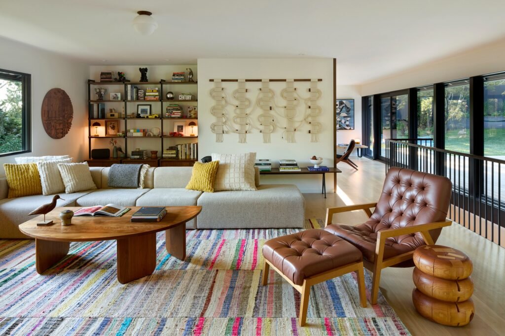 Spacious residential seating area featuring a large modular sofa, colorful woven area rug, and woven textile wall hanging.