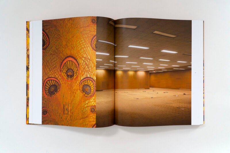 A book spread pairs the building’s peacock-feather pattern with an empty office interior.
