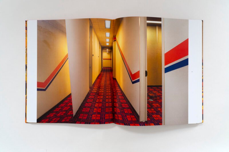 A corridor combines patterned carpet with red and blue striped walls.