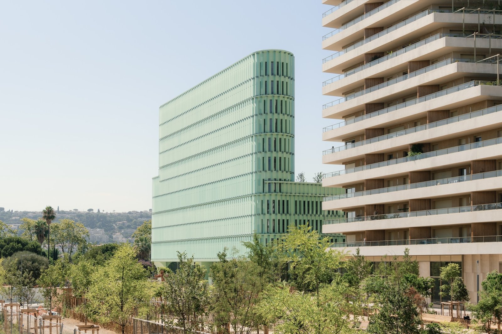 Lime-green Oasis student housing tower beside a neighbouring building in Nice