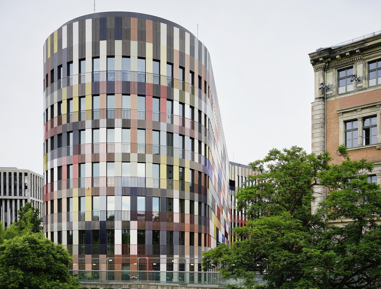 The rounded end of the taller volume beside the neighbouring urban fabric.
