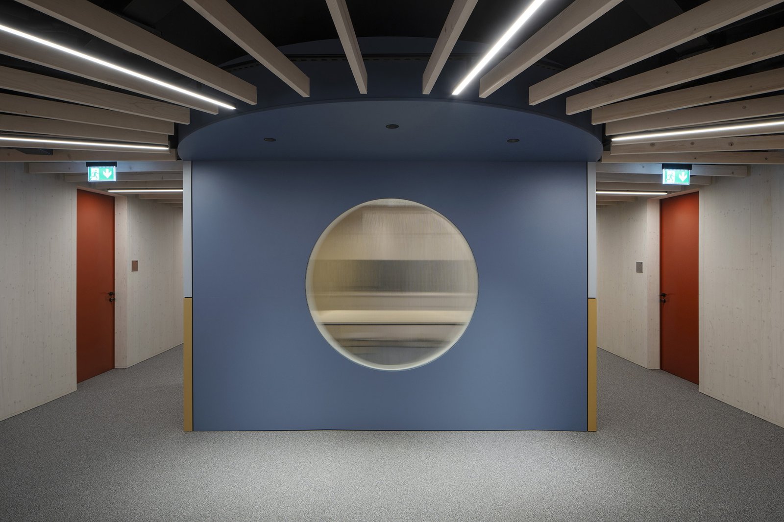 A circular window and coloured walls mark a junction in the interior circulation.