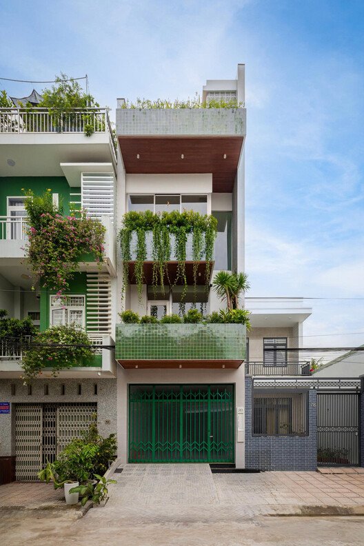 Planted balconies and green entrance gates on the street facade of Calm Haven House