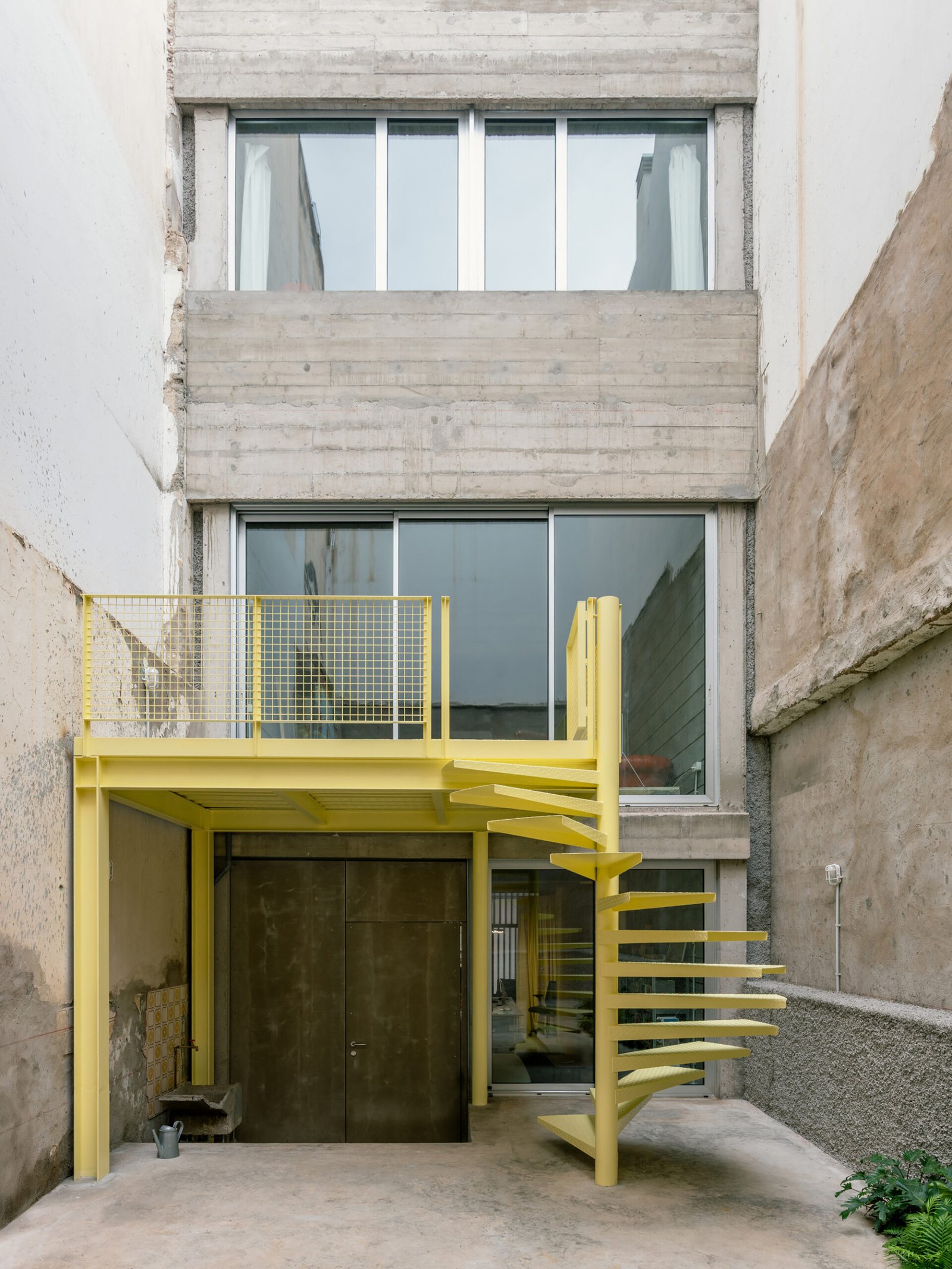 Casa Iriarte courtyard facade with a yellow exterior staircase / واجهة فناء كاسا إريارتي وسلمه الخارجي الأصفر