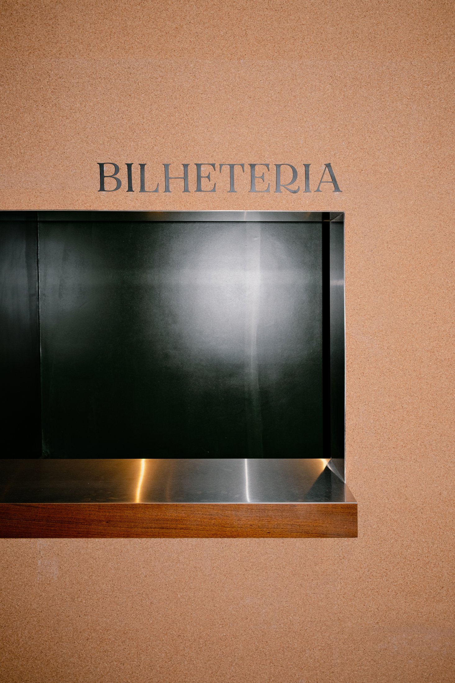 Ticket counter set into the warm-toned foyer wall
