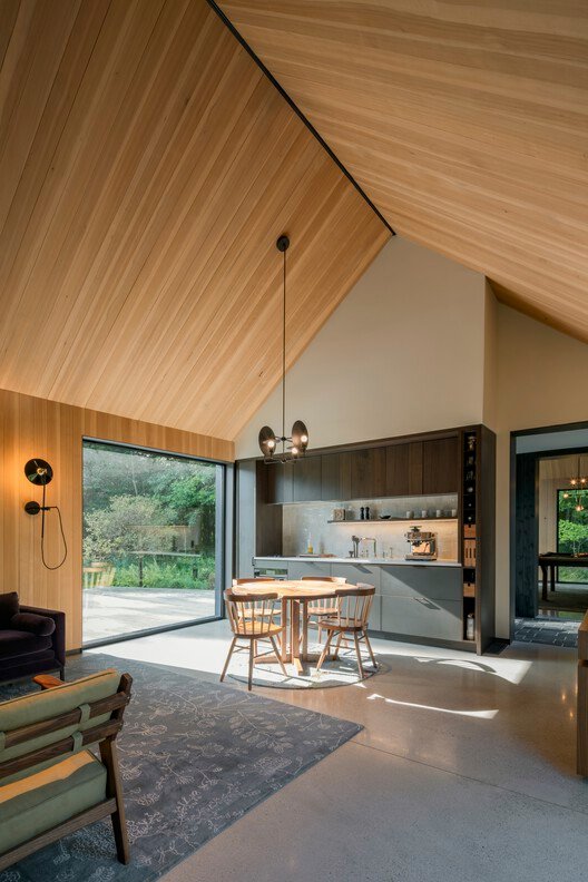Wood-lined pitched ceiling above the dining and shared living space.