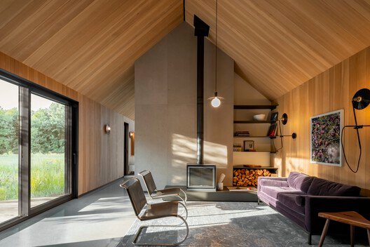 A wood-burning stove marks the living area beneath the pitched ceiling.