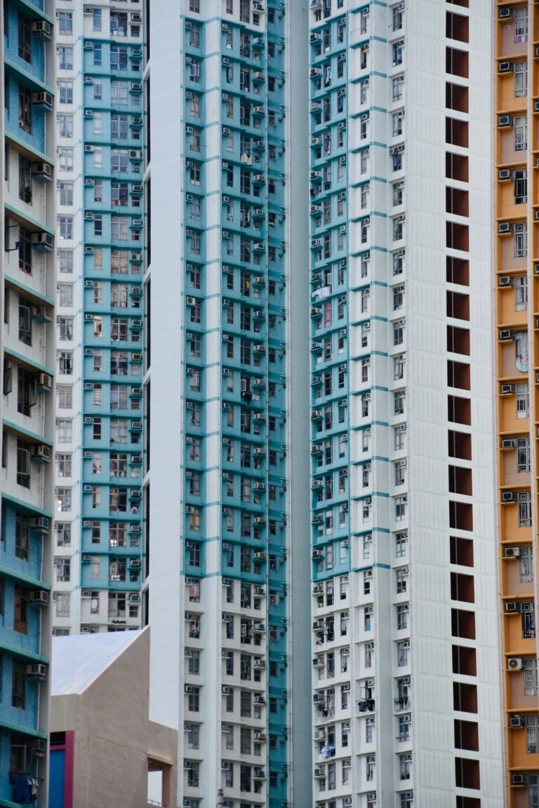 Closely spaced high-rise residential buildings with repeated windows and balconies in Hong Kong.