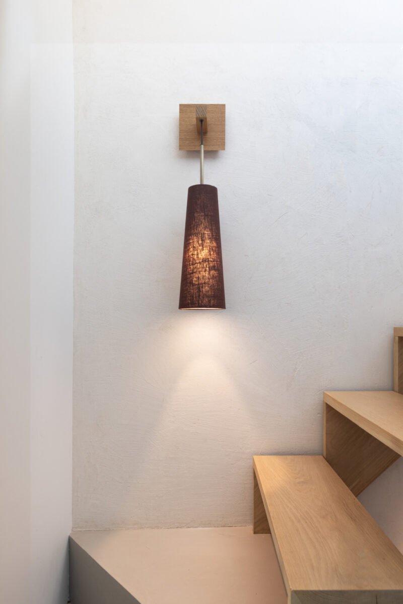 Strut wall light with an elongated fabric shade