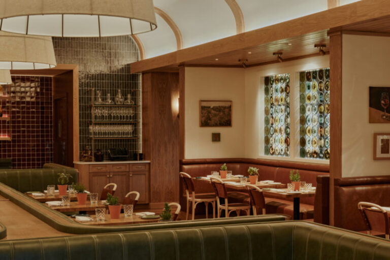 Olive booth backs and timber frames beneath a pale curved ceiling at Napa Bistro