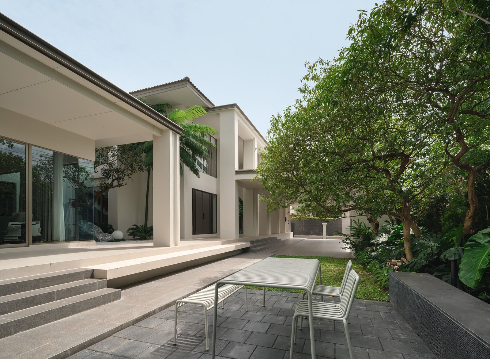 Concrete columns and shaded courtyard around the existing house