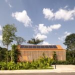 Pupunha House in Manaus: orange raised volume screened by planting / منزل بوبونيا في ماناوس بكتلة مرتفعة تحيط بها النباتات