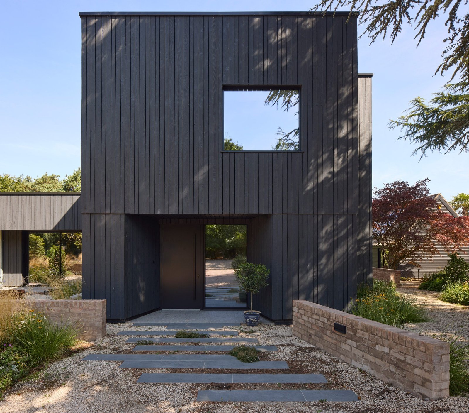 Sable House: charred timber elevation and sheltered courtyard entrance