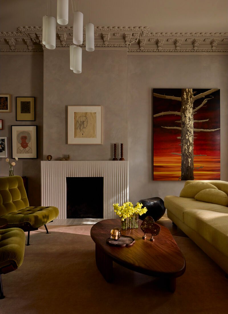 The tiled fireplace shares the living room with furniture and art.