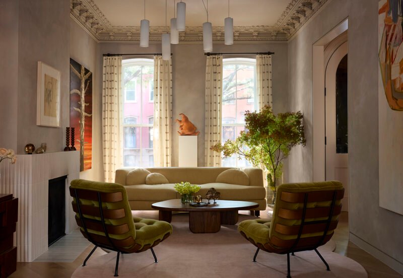 Restored ceiling ornament frames the living-room seating and chandelier.