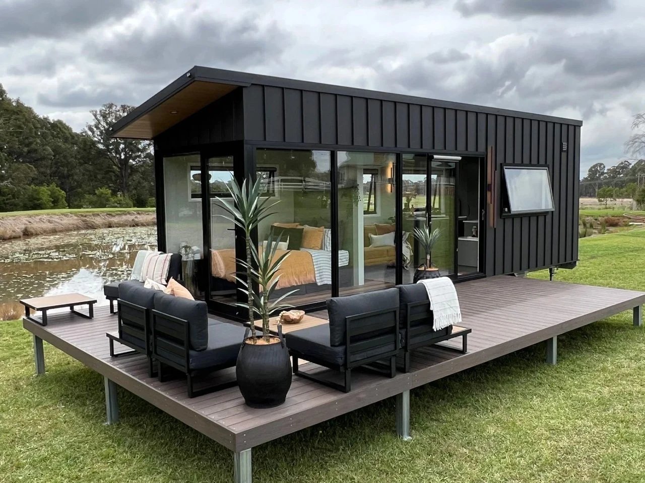 Jamison 8.4 with dark metal cladding, glazed walls and an outdoor deck | جاميسون 8.4 بكسوة معدنية داكنة وواجهات زجاجية ومنصة خارجية