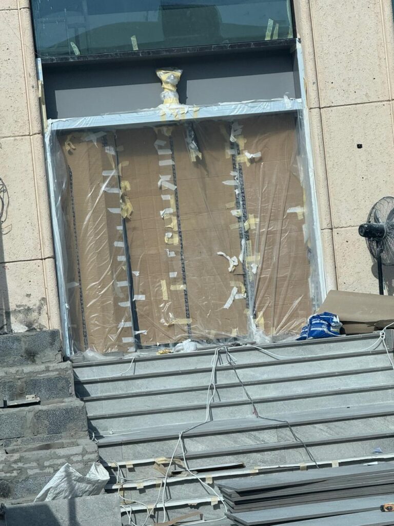 مدخل مبنى مغطى بالورق المقوى والأغطية البلاستيكية أثناء أعمال التجديد
