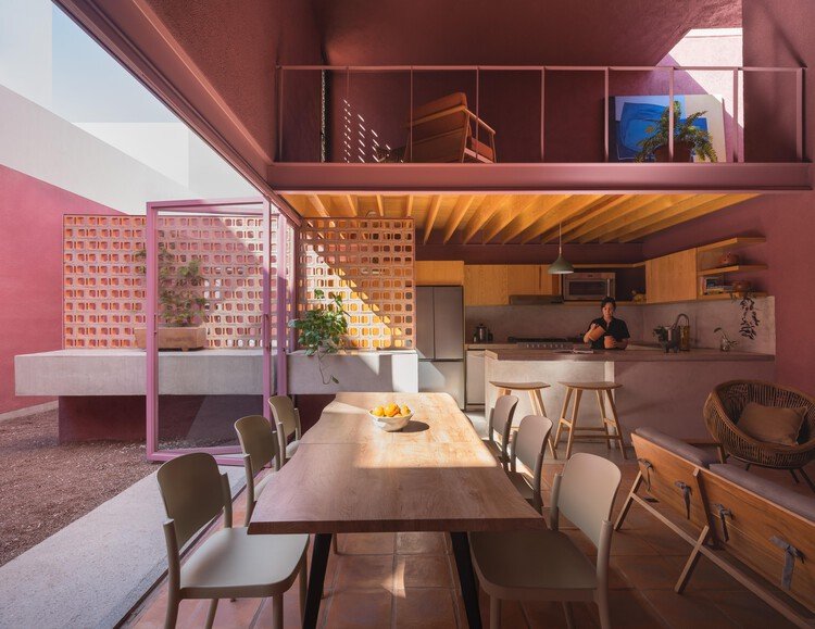 The kitchen occupies the lower zone beneath a gallery beside the taller dining space