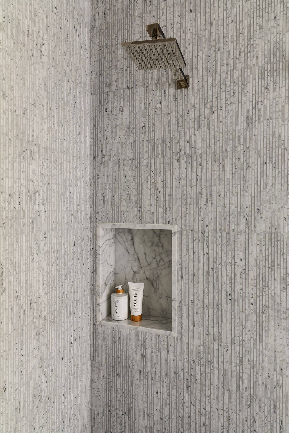 A recessed niche interrupts the repeated mosaic with a stone-lined opening.