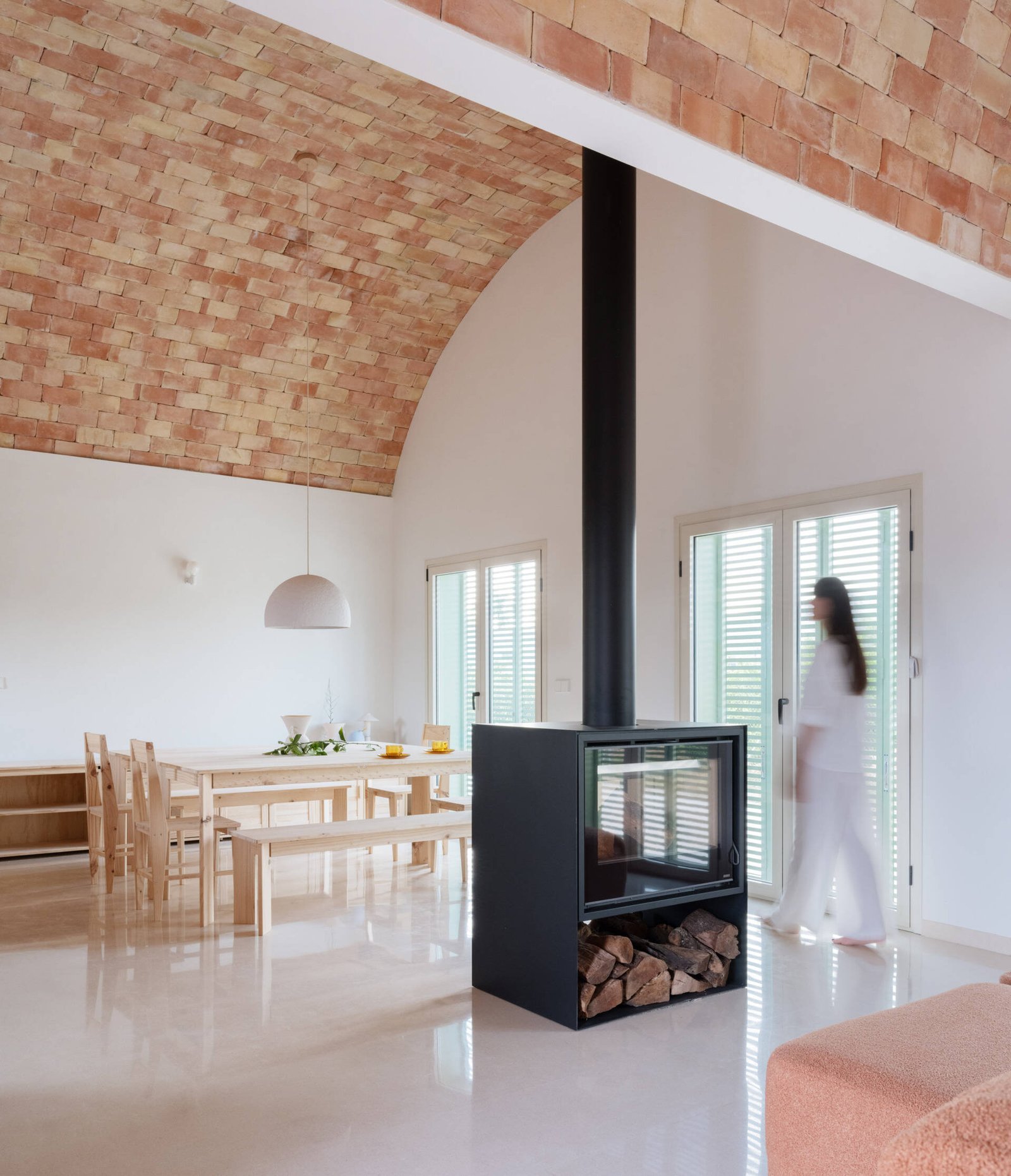The freestanding fireplace forms a partial boundary within the shared room.