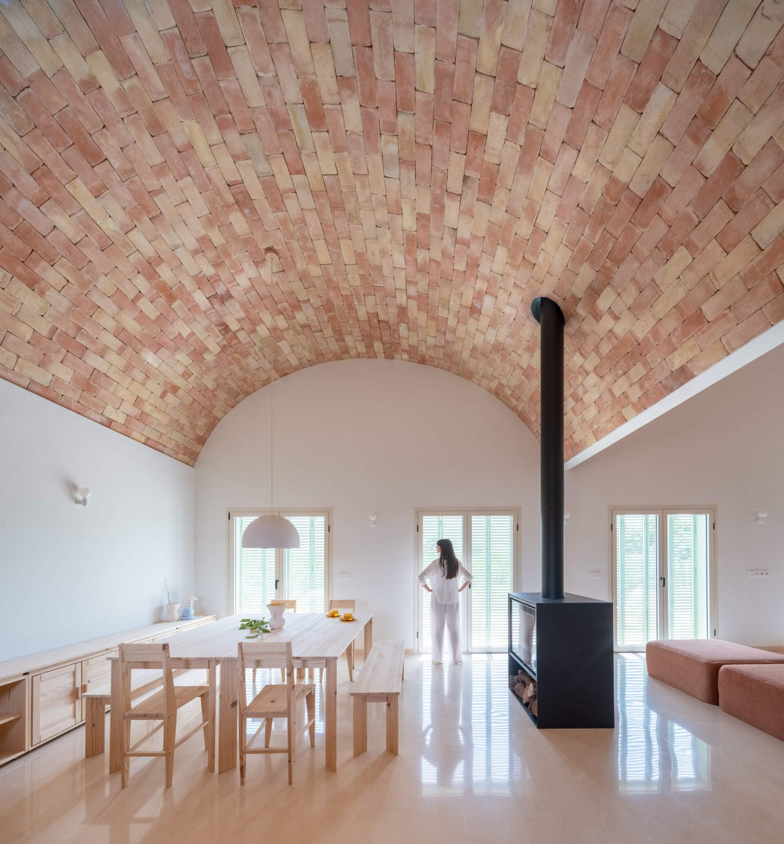 Dining occupies a generous volume under the brick vault.