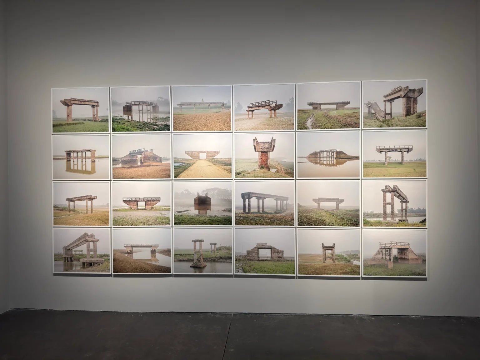 A grid of colourful architectural illustrations showing freestanding structures and landscape settings on a gallery wall at Hayy Jameel.