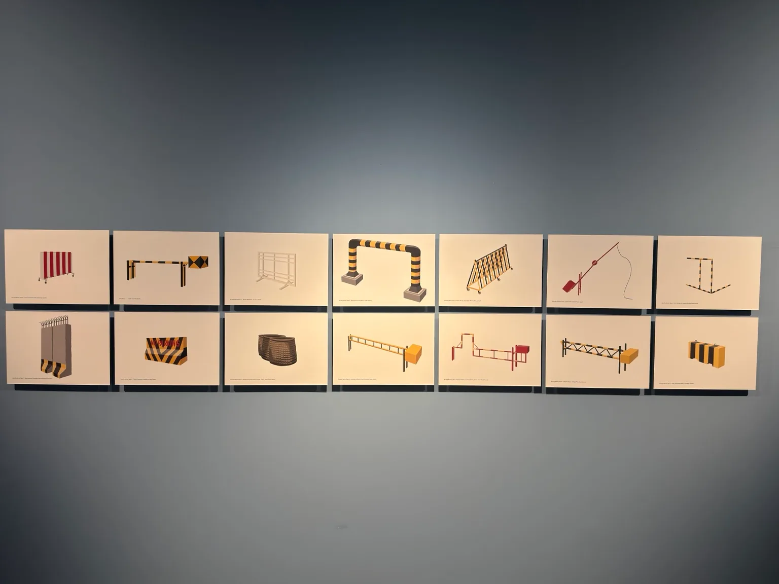 Two rows of small pale panels containing architectural and geometric studies mounted on a blue gallery wall at Hayy Jameel.