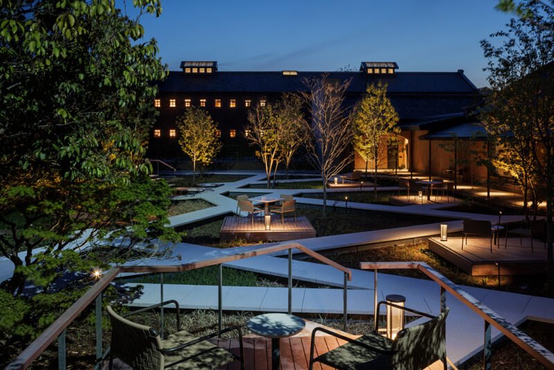 Courtyard at dusk with geometric paths, planting and private decks